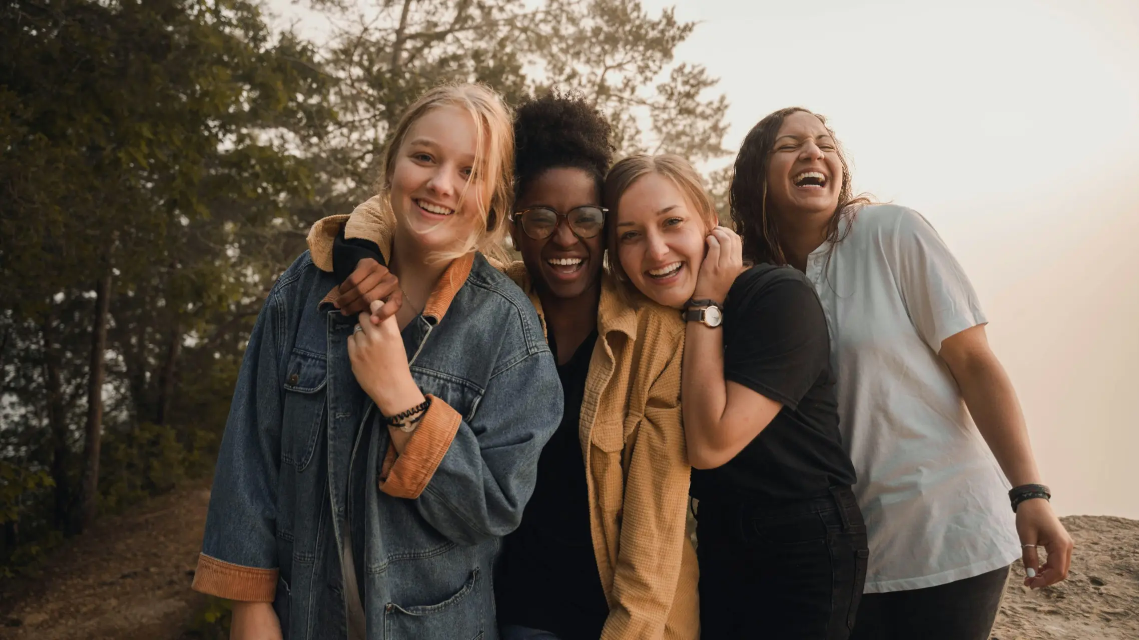 diverse group of young women embracing and laughing