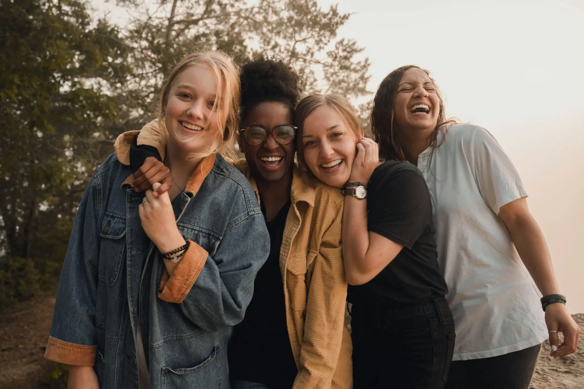diverse group of young women embracing and laughing