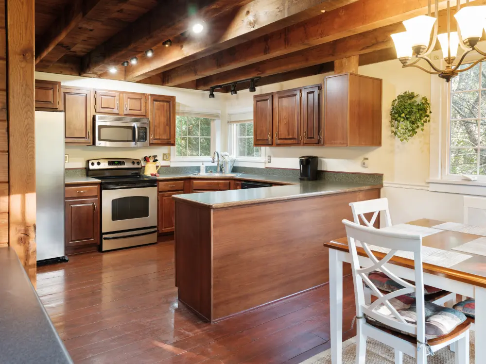 modern u-shaped kitchen layout with grayish granite countertops, wood cabinets, and stainless steel appliances